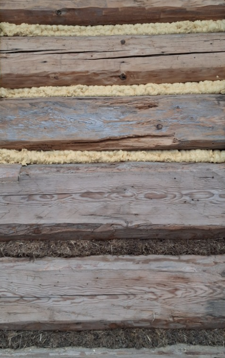 Piana PUR widoczna pomiędzy balami domu drewnianego